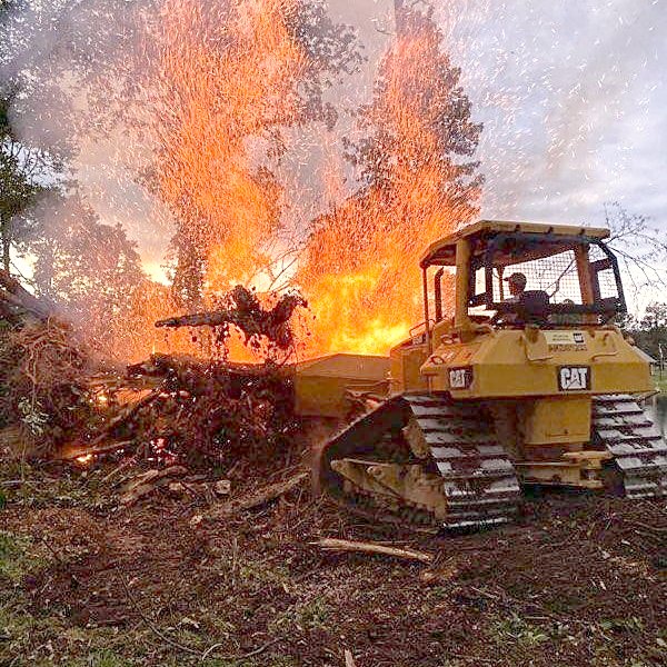Dozer working a brush burn on a clearing job