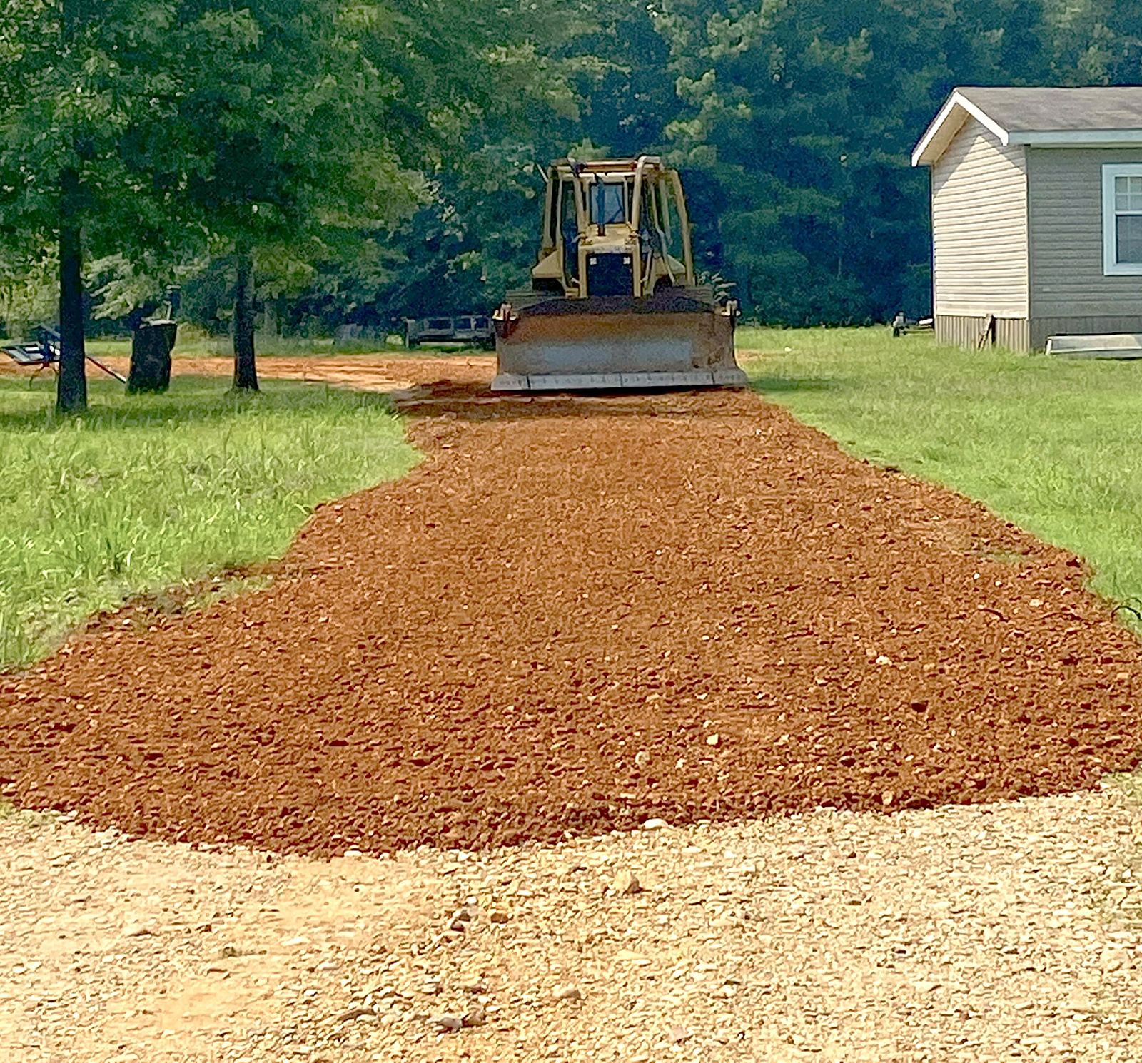 Fresh red gravel driveway beside a home